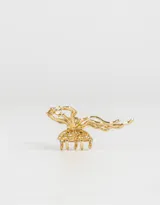 Broche para el pelo dorado con forma de moño.