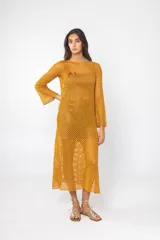 Vestido midi de red color mostaza, con mangas largas acampanadas y cuello redondo.