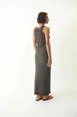 Vestido largo hasta los tobillos de calce ajustado, color gris oscuro. Tiene cuello redondo y un leve efecto desgastado.