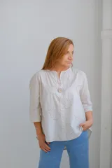 Blusa color beige con bordados de paisley y mangas 3/4. Tiene cuello mao y un botón de madera.