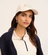 Gorra color crema con bordado frontal de la palabra "Athletic" en celeste.