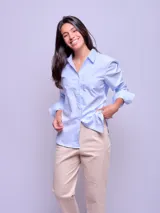 Camisa entallada de manga larga color rosa claro, con cuello clásico y cierre frontal con botones.