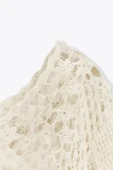Top de crochet color crema, con cuello redondo y mangas cortas.
