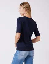 Buzo de punto fino color azul marino, con cuello redondo y mangas cortas.