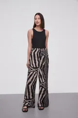 Pantalón de viscosa con estampado abstracto en tonos beige y negro, de corte palazzo y cintura con lazo ajustable.
