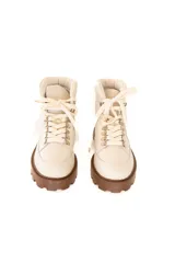 Borcego acordonado color crudo, con suela marrón de goma con plataforma y cordones al tono.