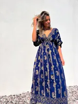 Vestido largo azul con estampado de cachemir dorado, escote en V, mangas cortas y cintura imperio con cordón ajustable.