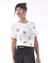 Remera de manga corta color blanco roto con cuello redondo y estampado de ojos y estrellas en tonos grises.