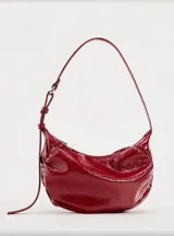 Bolso de hombro negro de cuero sintético con frunces y cierre superior con cremallera.