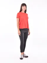 Remera de poliéster color coral, de corte clásico y mangas cortas.
