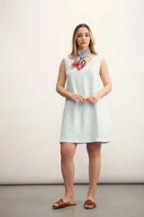 Vestido corto color negro, sin mangas, con escote en V y bolsillos laterales.