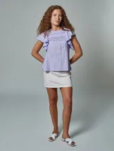 Blusa lila de algodón con bordado calado en el cuello y volados en las mangas.