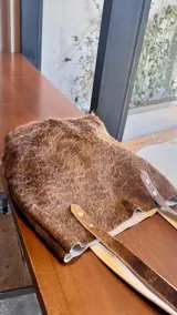 Cartera Nómade confeccionada artesanalmente en cuero con pelo color marrón. Cada pieza es única debido a las variaciones naturales del cuero.