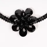 Collar de tres hilos de cuentas negras con dije de flor de cristal tornasol.