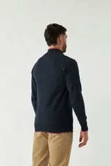 Campera tejida azul marino con cuello alto, cierre frontal y puños acanalados con detalle de línea roja.