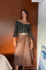 Falda midi marrón de cuero sintético, corte evasé, con cinturón con hebilla circular.
