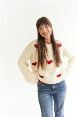 Sweater color crema de lana merino, tejido a mano, con corazones rojos.