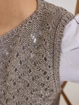 Chaleco de tejido calado color verde oliva, sin mangas y con cuello redondo.