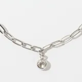 Pulsera de eslabones alargados plateados, con un pequeño dije de cristal redondo colgante. Posee cierre de mosquetón y cadena de ajuste.