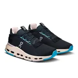 Championes negros de la marca On Running, modelo Cloudnova 2, con detalles en celeste y suela color crema.