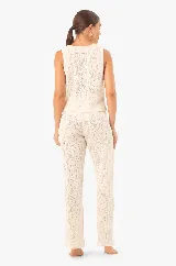 Chaleco de punto color crudo, con escote en V, abertura frontal y cierre con cordones.