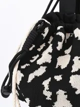 Bandolera negra con estampado animal print en blanco, doble asa corta y correa larga regulable.