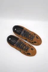 Zapatillas urbanas de cuero color crema con puntera y talón en gamuza gris, suela de goma marrón y cordones grises.