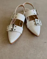 Chatas de cuero blanco con diseño elegante y cierre en hebilla.