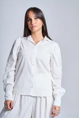 Camisa blanca de mangas largas con broderie y botones perlados.