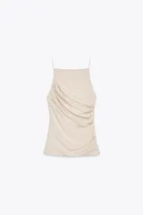 Top halter color beige con tirantes finos y detalle de frunces en el lateral.