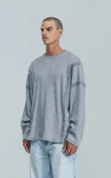 Sweater gris de manga larga con cuello redondo y costuras decorativas en los hombros y laterales.