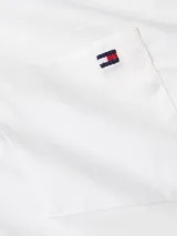 Camisa blanca de popelina de algodón BCI, de corte clásico, con cuello abotonado, cierre frontal con botones, bolsillo en el pecho y logo de Tommy Hilfiger bordado.