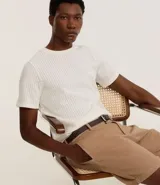 Remera de hombre color crudo, de punto calado con textura de encaje, cuello redondo y mangas cortas. Corte regular. Confeccionada en poliéster y algodón.