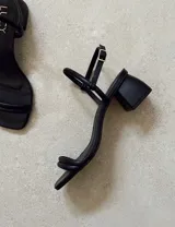 Sandalias doradas de fiesta con tiras finas y taco cuadrado bajo.