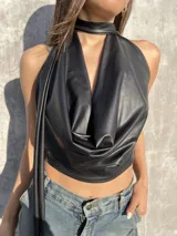 Top negro de ecocuero con cuello halter y espalda descubierta.