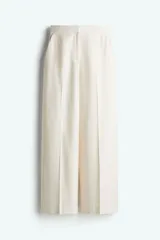 Pantalón de vestir color crema, de tiro alto, corte ancho y largo midi.