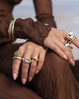 Brazalete rígido dorado con textura irregular.
