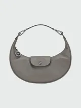 Bolso bandolera pequeño de cuero color gris con forma de media luna, cierre superior con cremallera y botón a presión, correa de cuero ajustable y extraíble, y herrajes plateados.