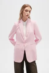 Blazer blanco de lino con hombreras, corte entallado, cuello solapa y cierre con botón.