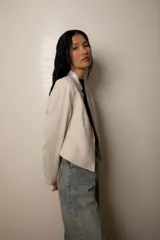 Blazer color crema con bordado a tono, corte sastrero, cuello mao blanco y botón forrado.