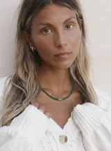 Gargantilla de cuentas facetadas color verde esmeralda, con dije cuadrado de cristal y cierre de acero con baño de oro.