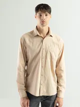 Camisa de manga larga color beige confeccionada en 100% algodón, de corte clásico y con bolsillo en el lado izquierdo del pecho.