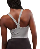 Top deportivo blanco, ajustado al cuerpo, con escote redondo en el frente y espalda cruzada. Presenta un dobladillo recortado que deja ver el abdomen.