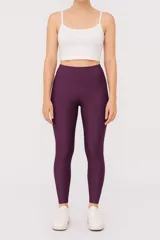 Calza larga de poliéster color violeta, de punto canalé, tiro alto y calce ajustado al cuerpo.