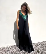 Vestido largo negro con escote en V y apliques de lentejuelas verdes en la parte superior.