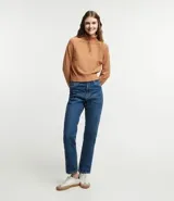 Blusa de punto color blanco, con cuello alto, manga larga y diseño liso.