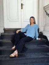 Sandalias de cuero color crudo, con dos tiras anchas sobre el empeine, pulsera al tobillo con hebilla y taco cuadrado de madera.