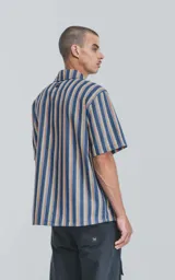 Camisa de manga corta con cuello cubano y estampado a rayas verticales en tonos azul, amarillo y rojo.