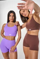 Conjunto deportivo violeta compuesto por un top con breteles cruzados en la espalda y logo "bk." en el frente y un short de calce ajustado.