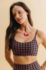 Top corto de traje de baño, color negro con estampado floral en tonos rosados y naranjas. Tiene escote redondo y breteles finos.